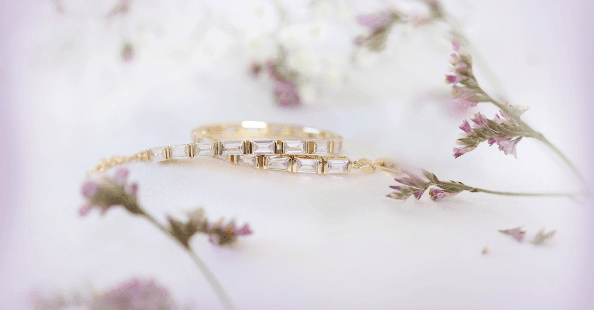 Smykker som julegaver Nærbilde av et armbånd med blanke stener som ligger omringet av blomster