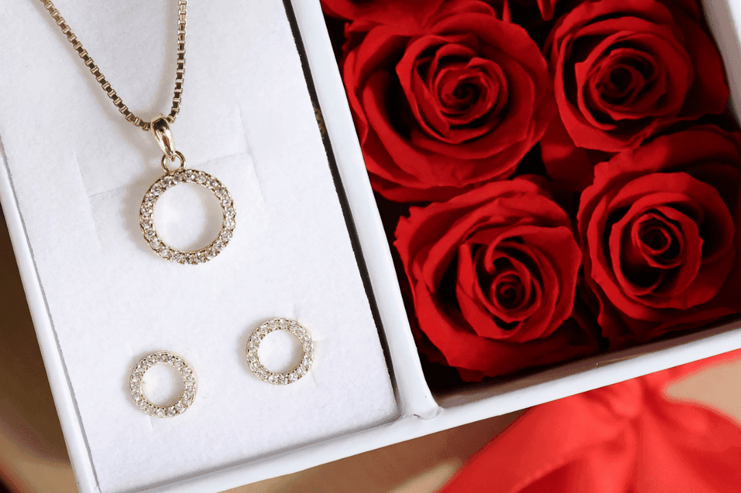 Sirkelsmykker fra Bjørklund Smykkesett som ligger i en gaveeske fra Bjørklund fylt med røde roser