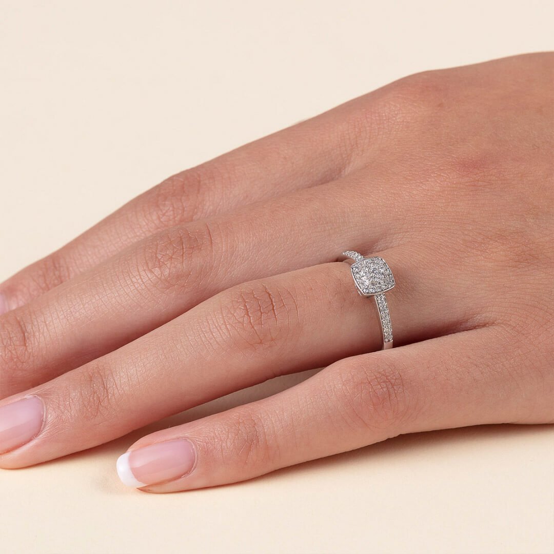 Et nærbilde av en godt vedlikehold kvinnehånd med diamantring. Dette er en ring med mange små diamanter dantert utover hele ringen.