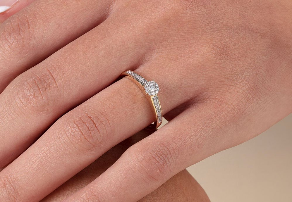 Se våre diamanter Nærbilde av en damehånd oppå en damearm, der damehånden har en skinnende diamantring.